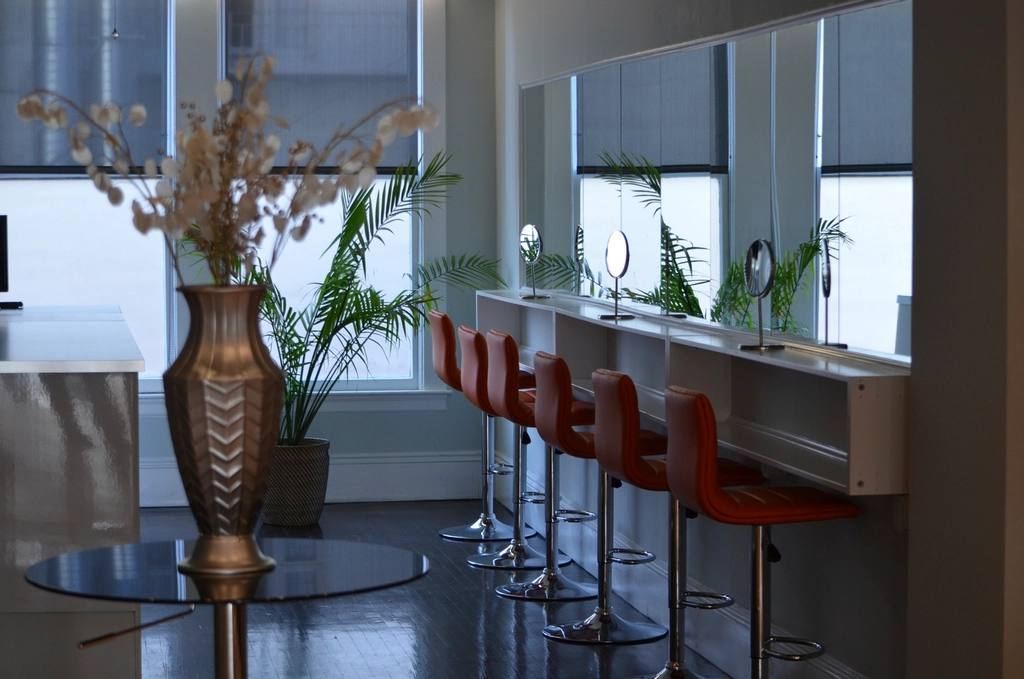 De salon met stoelen en spiegels bij daglicht